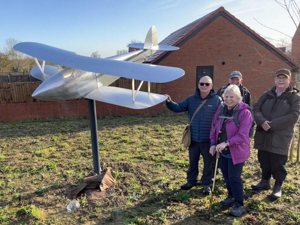Members of Walking Group A by plane on the site of the WWI airfield at Bury